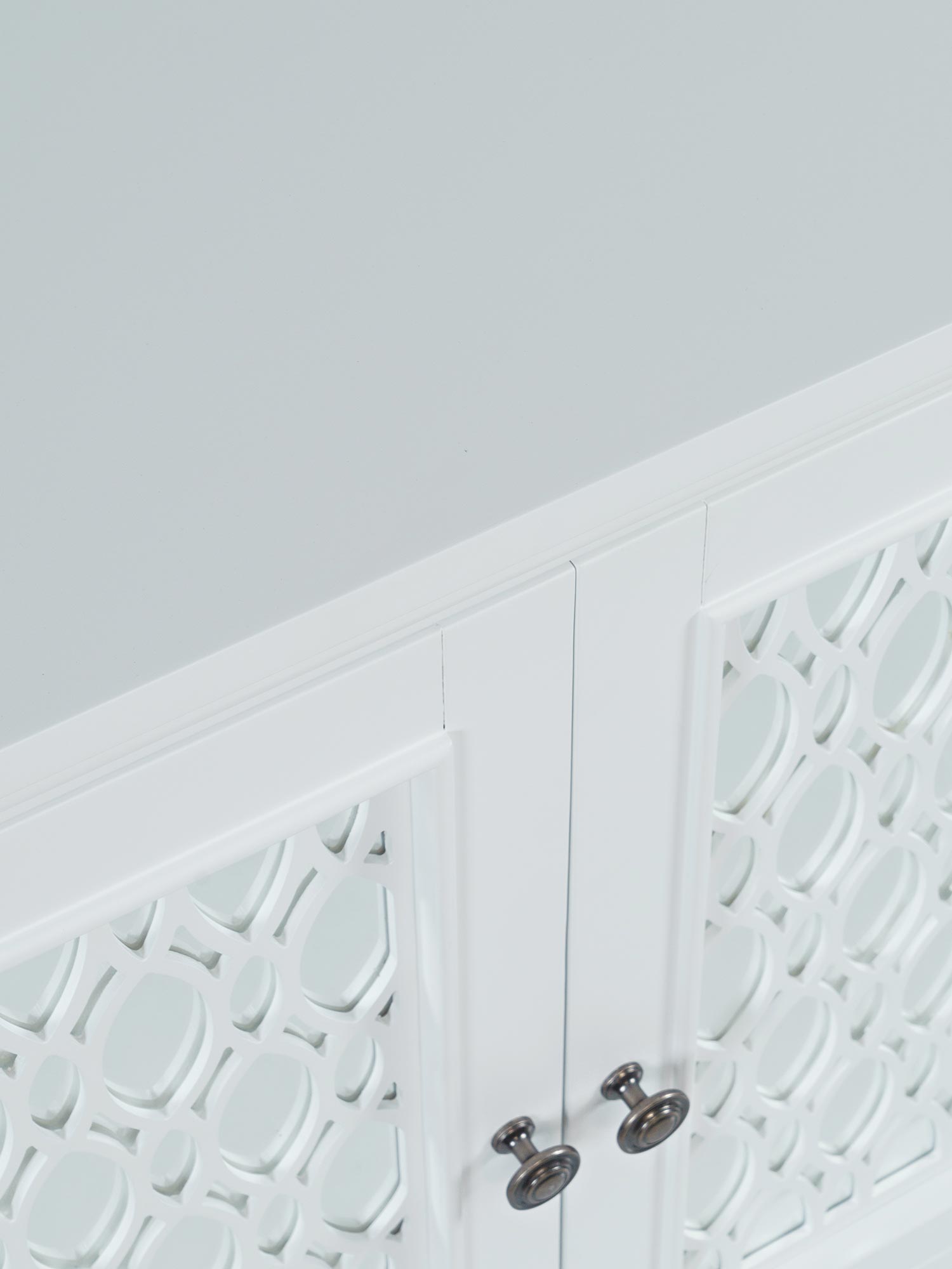 Detal dekoracyjnego frontu białej komody w stylu glamour