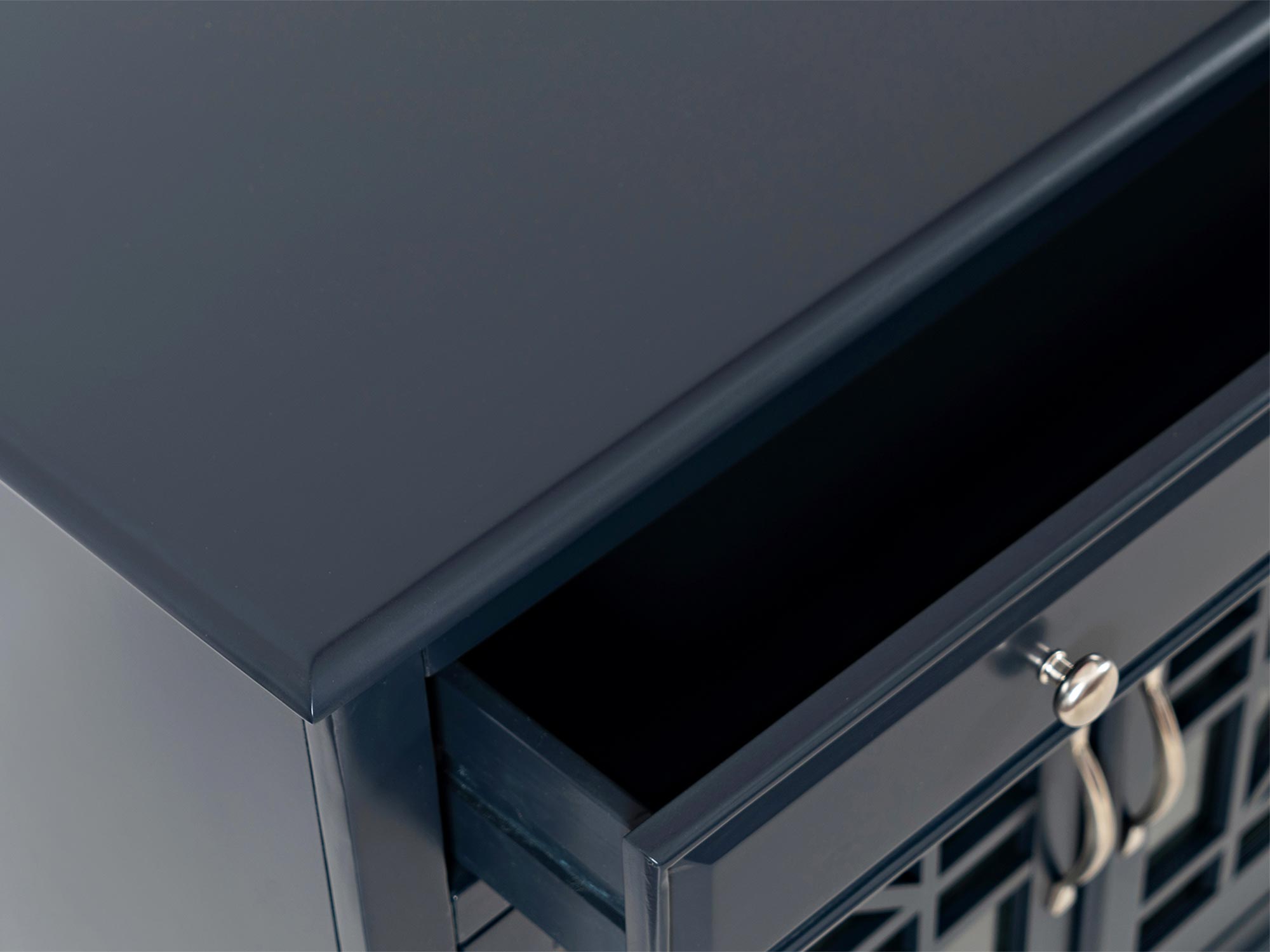 Szczegół wykończenia blatu czarnej drewnianej komody w stylu klasycznym