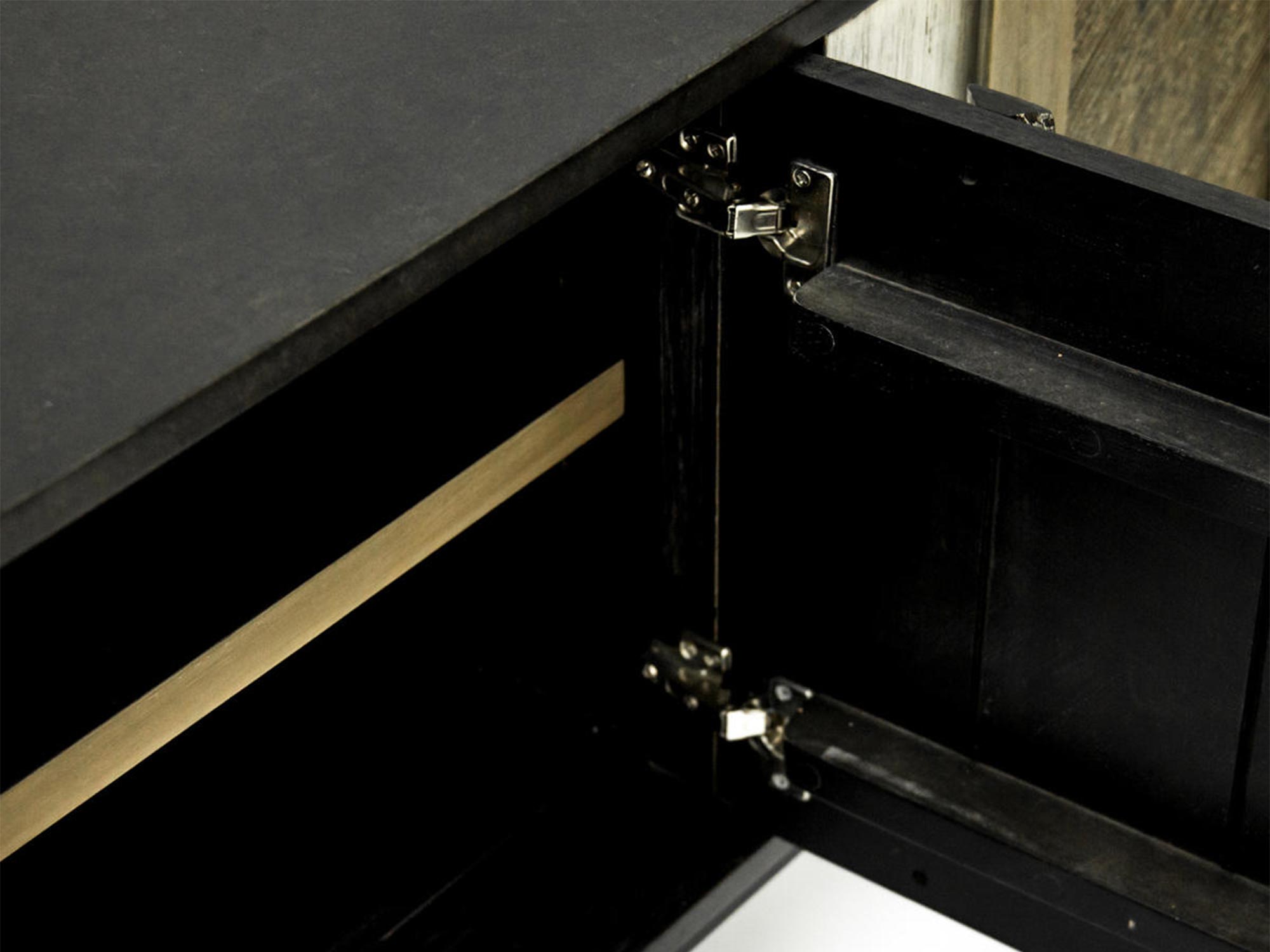 Detal metalowego zawiasu w czarnej komodzie w stylu industrialnym