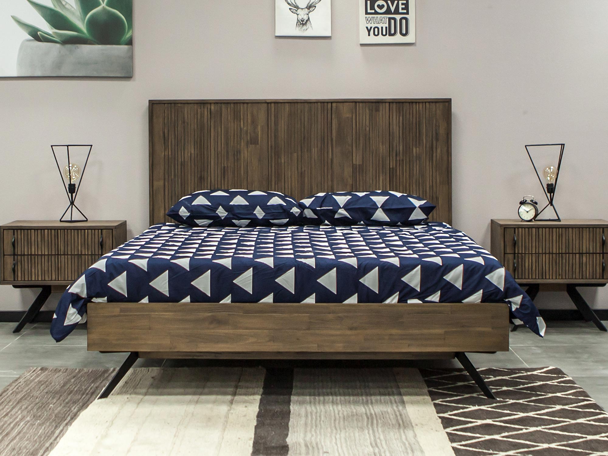 Łóżko z drewna akacjowego z granatową pościelą w sypialni Łóżko z drewna akacjowego z granatową pościelą w sypialni