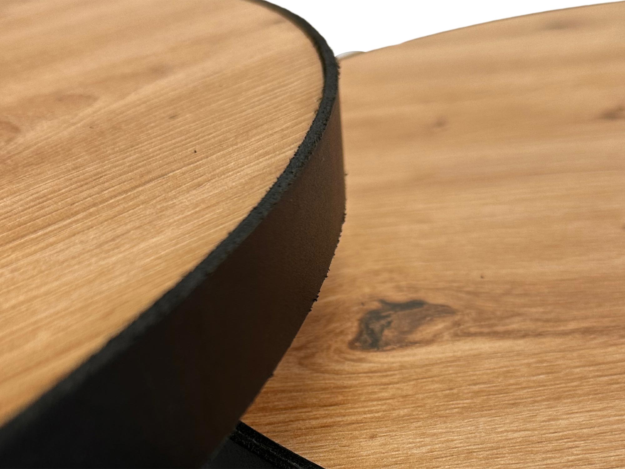 Zbliżenie na rant blatu okrągłego stolika z widocznym sękiem