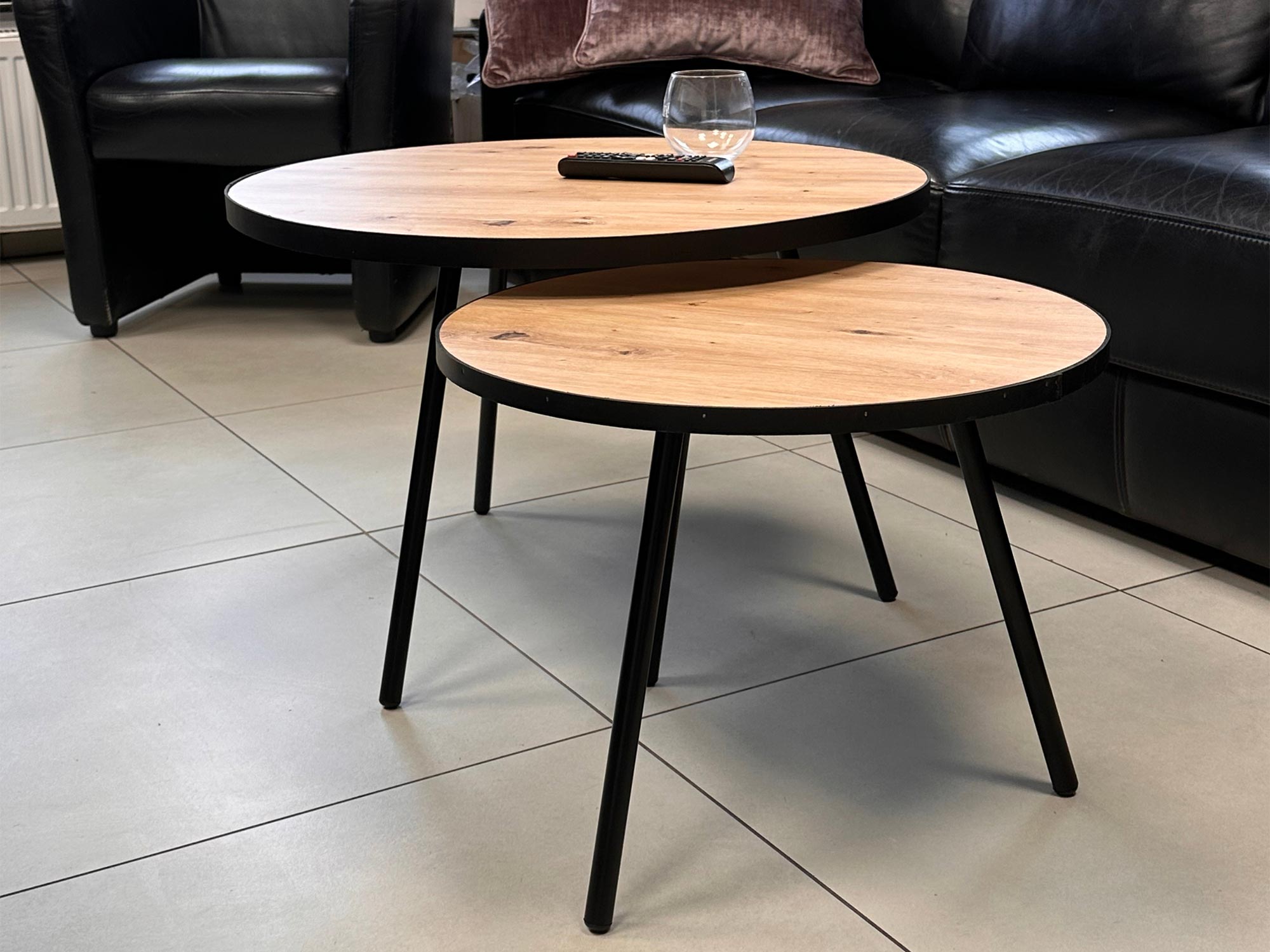 Dwa okrągłe stoliki w nowoczesnym salonie na płytkach