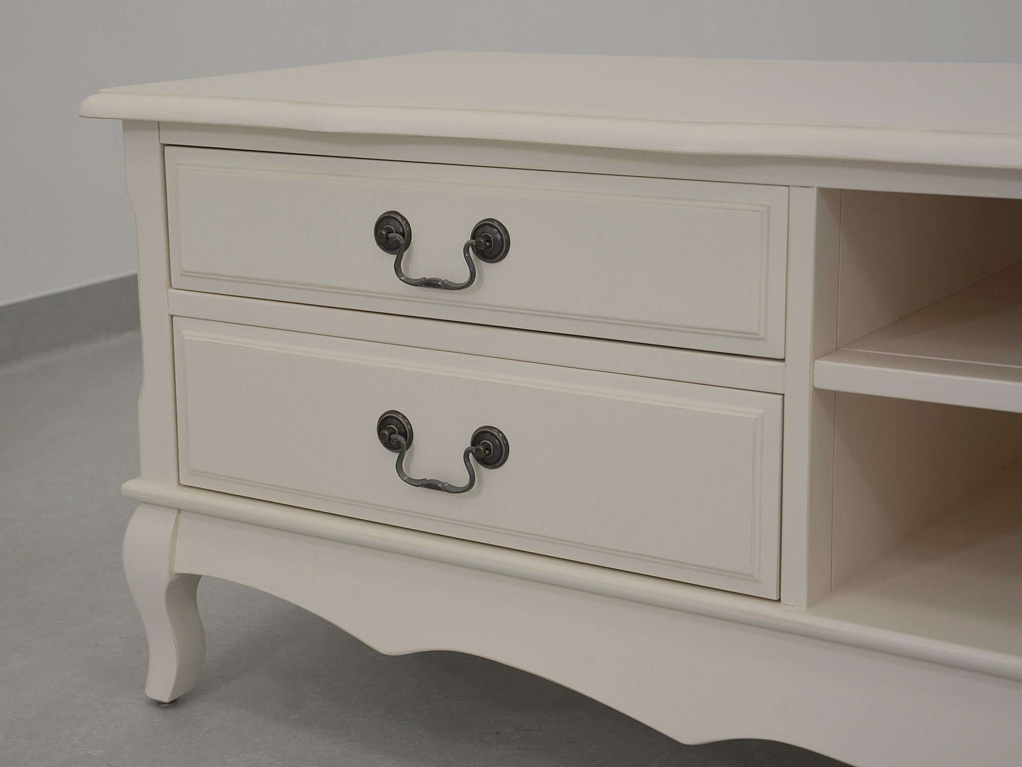 Biała szafka RTV z drewnianym blatem i ozdobnymi uchwytami retro