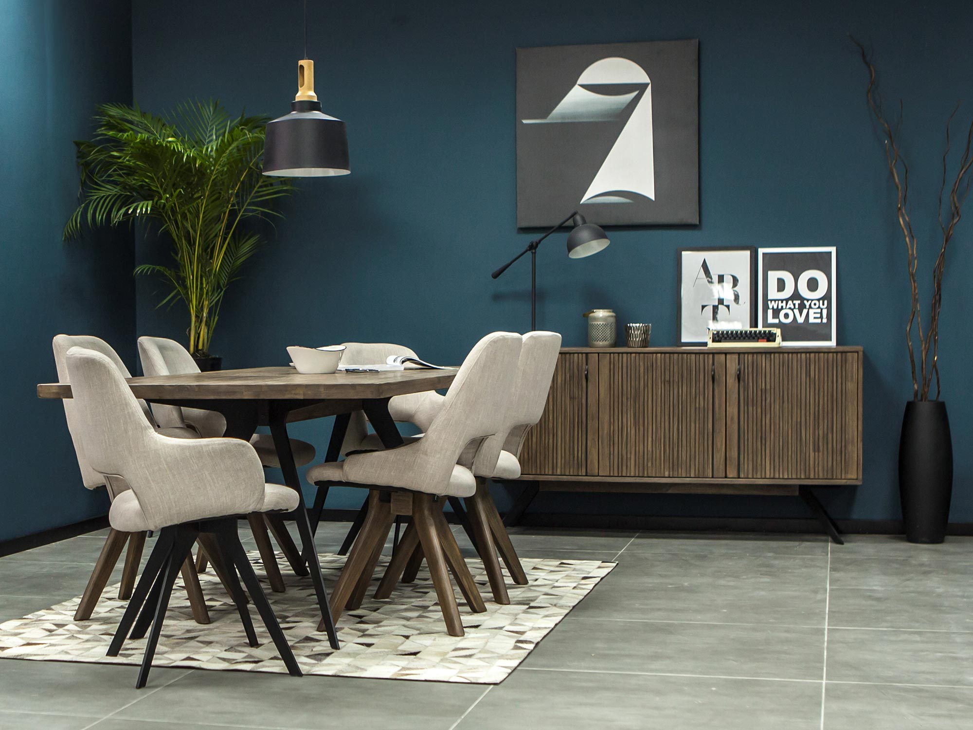 Stół z akacji i krzesła tapicerowane w industrialnym wnętrzu