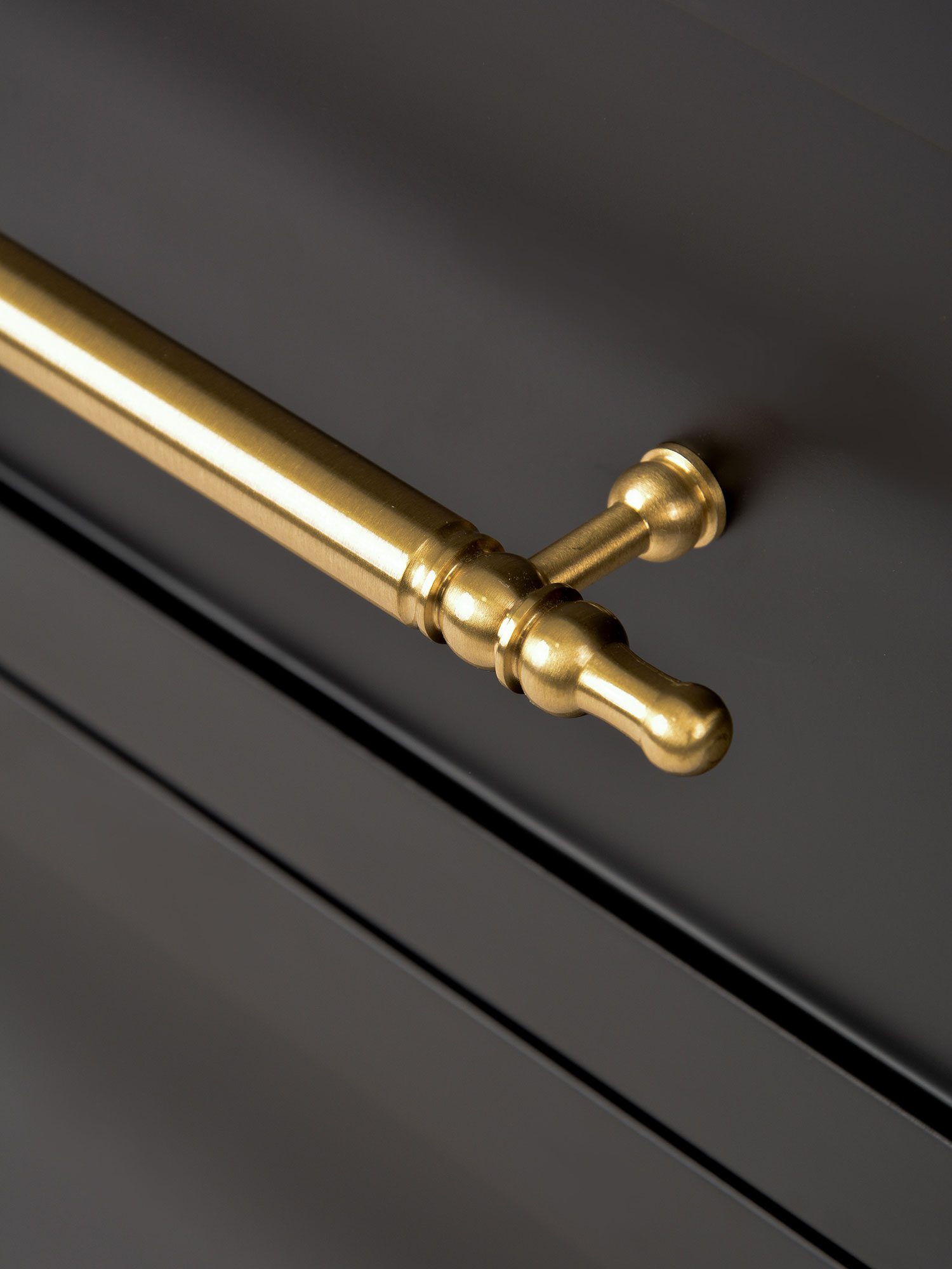 Zbliżenie na elegancki złoty uchwyt w stylu vintage na meblach z wiązu