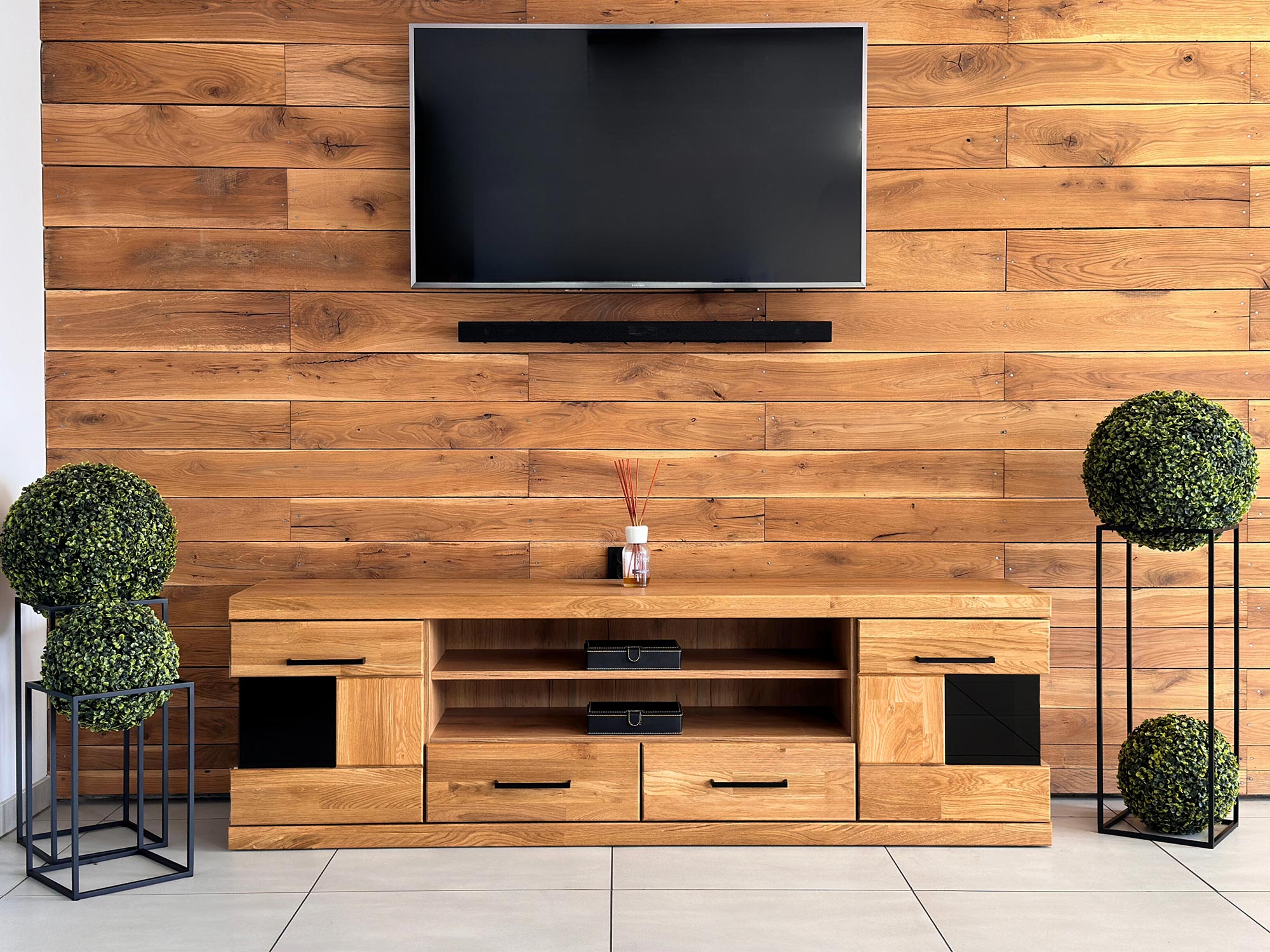 Drewniana szafka RTV pod telewizorem z czarnymi elementami