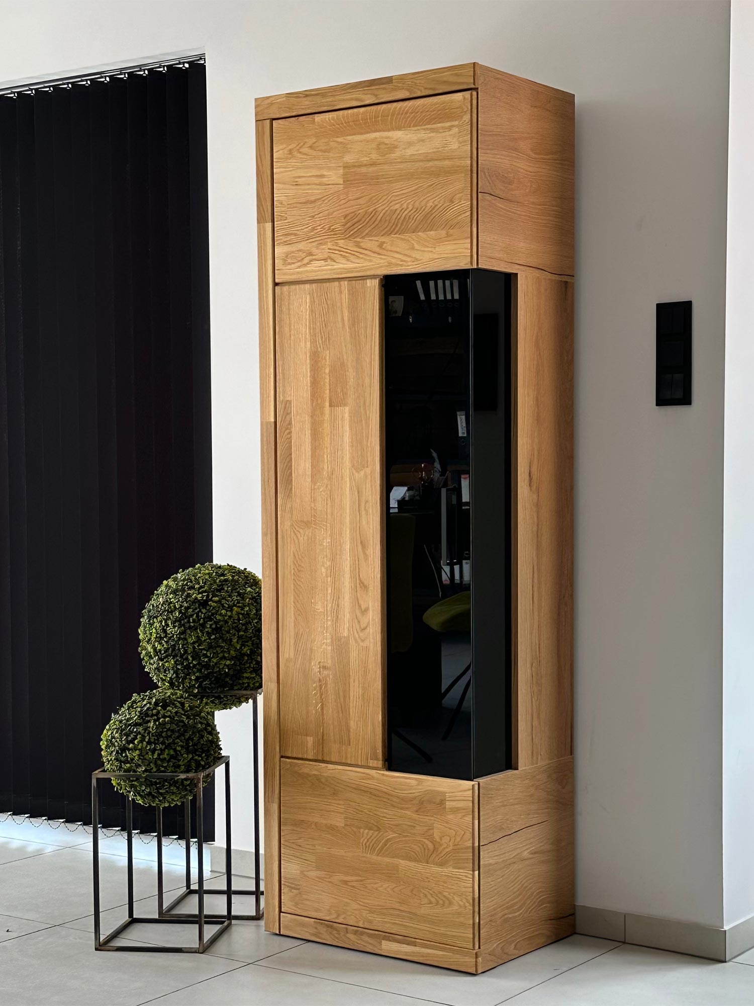 Witryna stojąca z czarnym frontem w aranżacji wnętrza