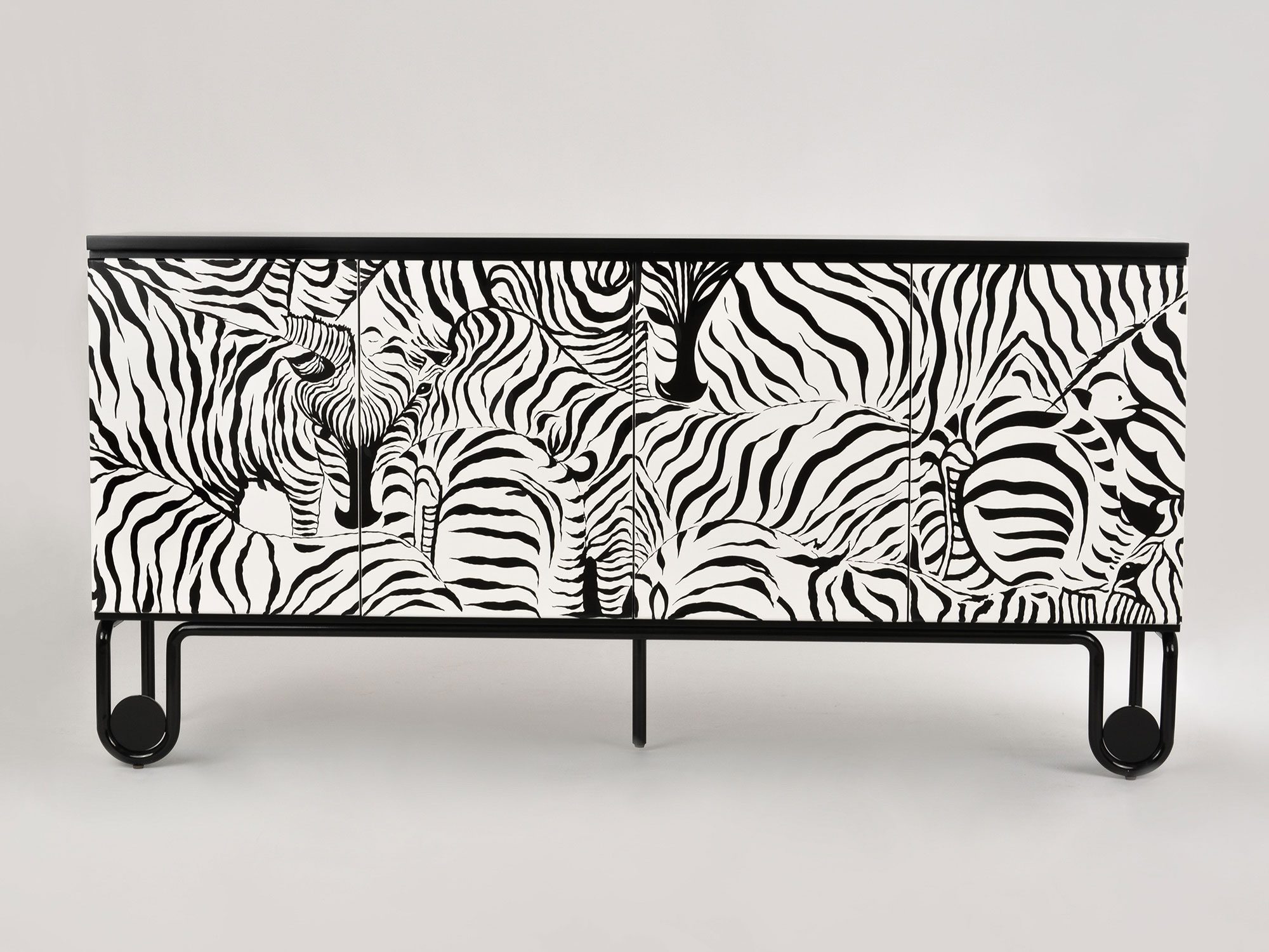 Detal komody z frontem w czarno-biały wzór zebry i metalową nogą