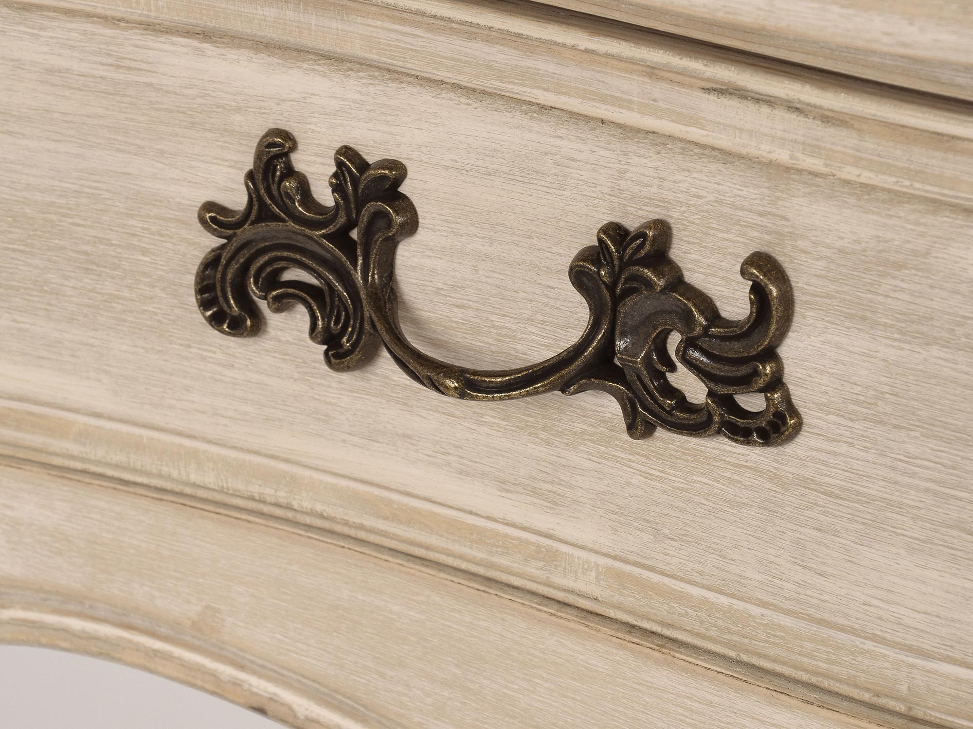 Zbliżenie na uchwyty w jasnobeżowej komodzie