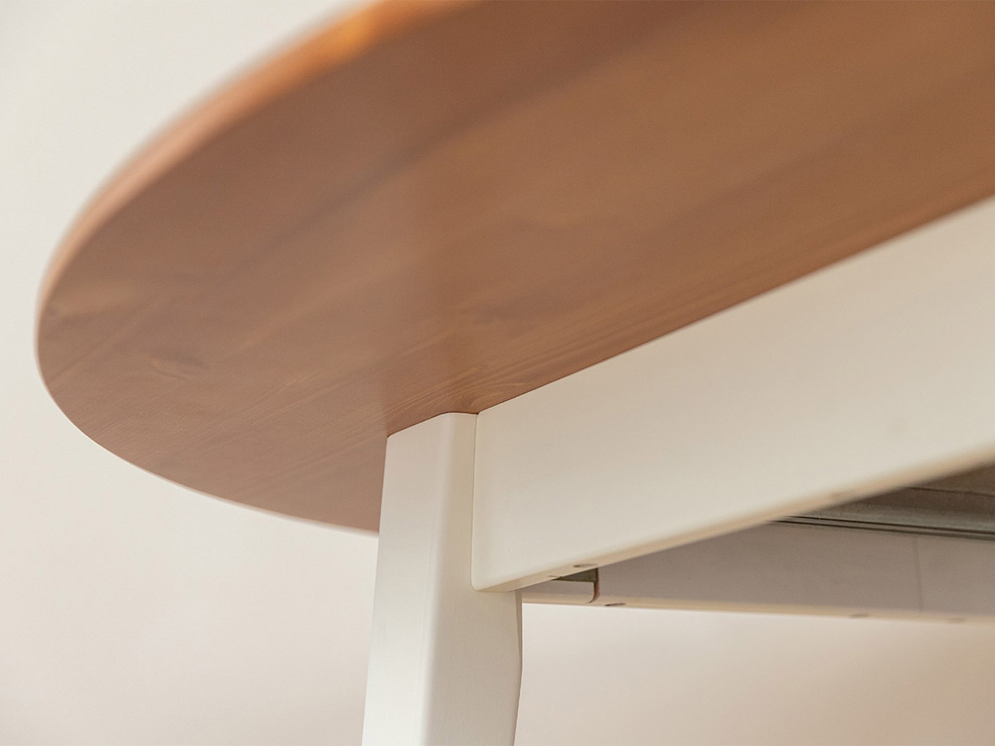 Detal białej nogi stołu rozkładanego z owalnym blatem dębowym zbliżenie