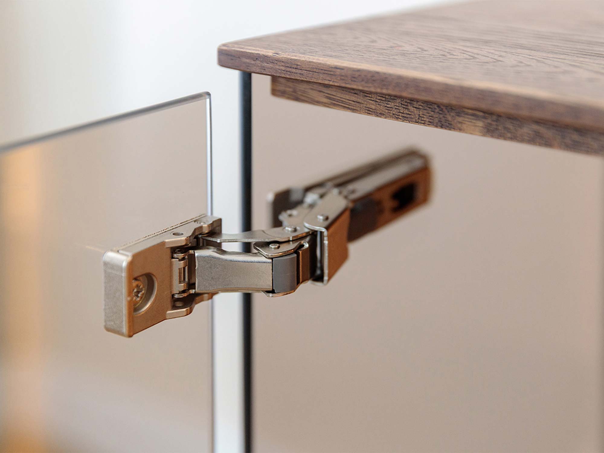 Detal zawiasu drzwi szklanych witryny tabacco z blatem dębowym