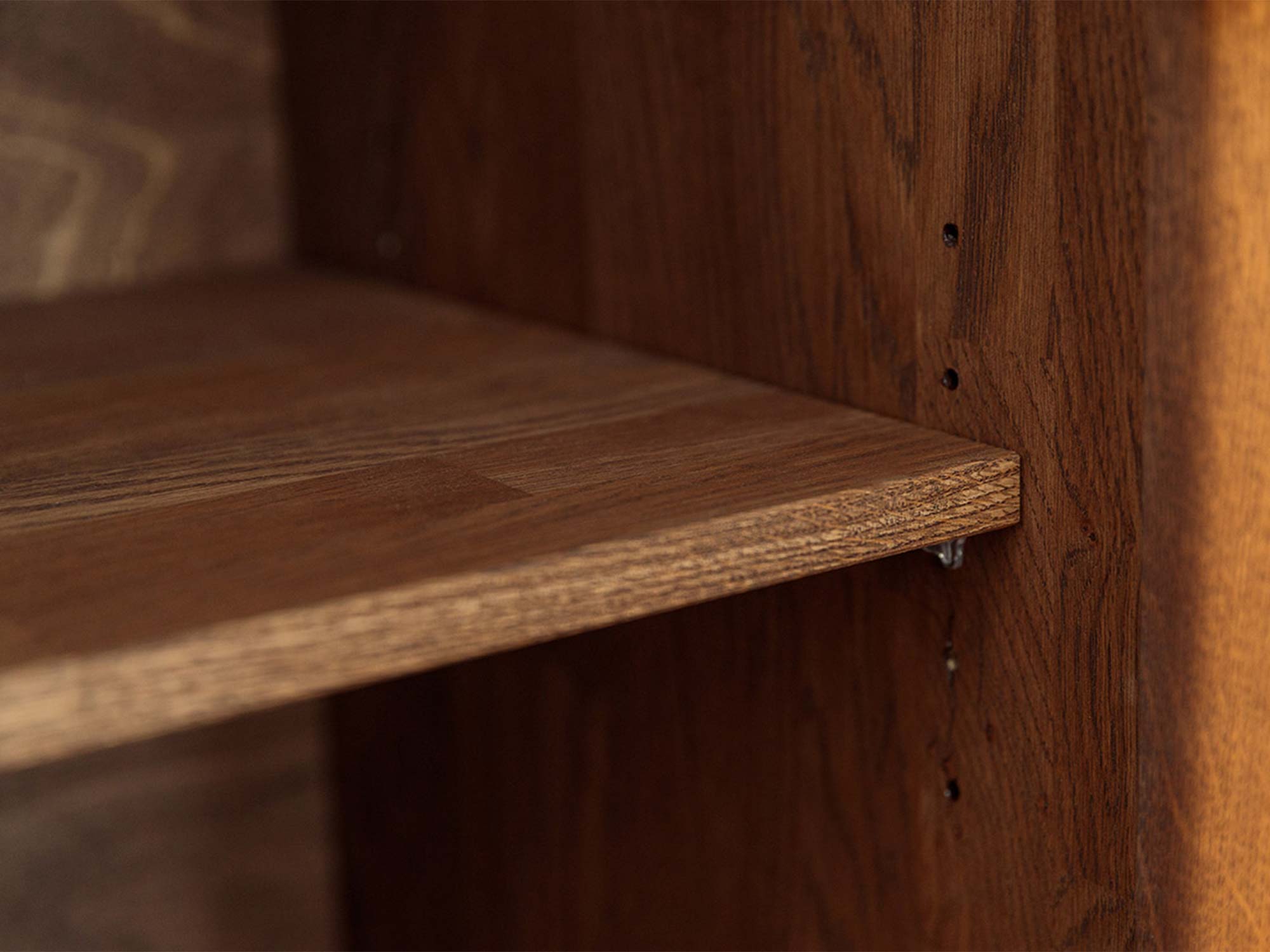 Detal półki drewnianej witryny tabacco z otworami regulacji wysokości