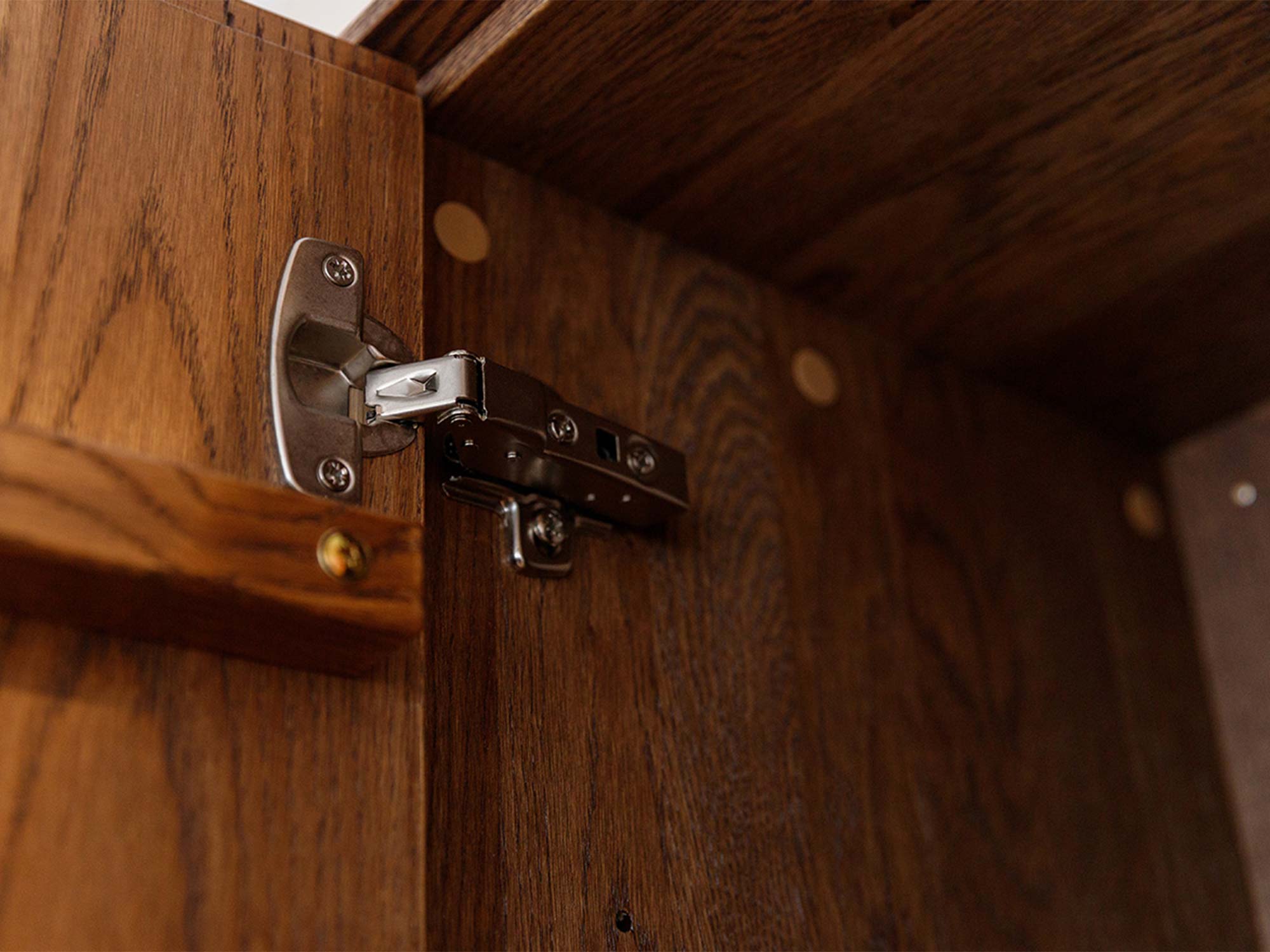 Detal zawiasu drzwi komody tabacco wewnątrz korpusu zbliżenie