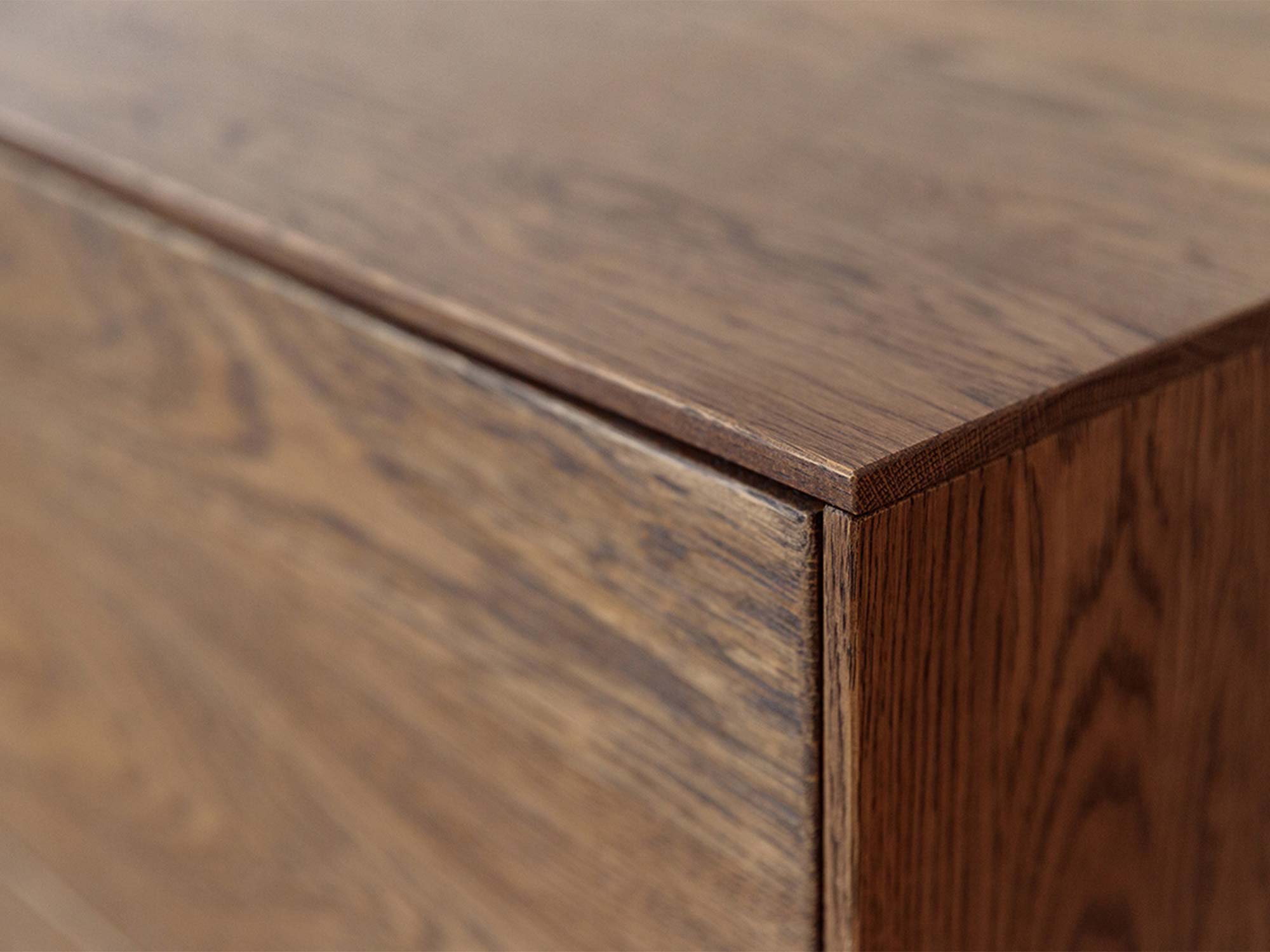 Detal blatu i narożnika komody tabacco z usłojeniem drewna dębowego