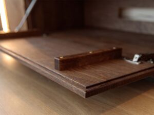 Miniatura 3 - Detail otwartej klapy komody tabacco s dřevěným úchyty a podsvícením LED