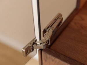 Miniaturka 7 - Detal zawiasów drzwi witryny tabacco z widocznym usłojeniem drewna