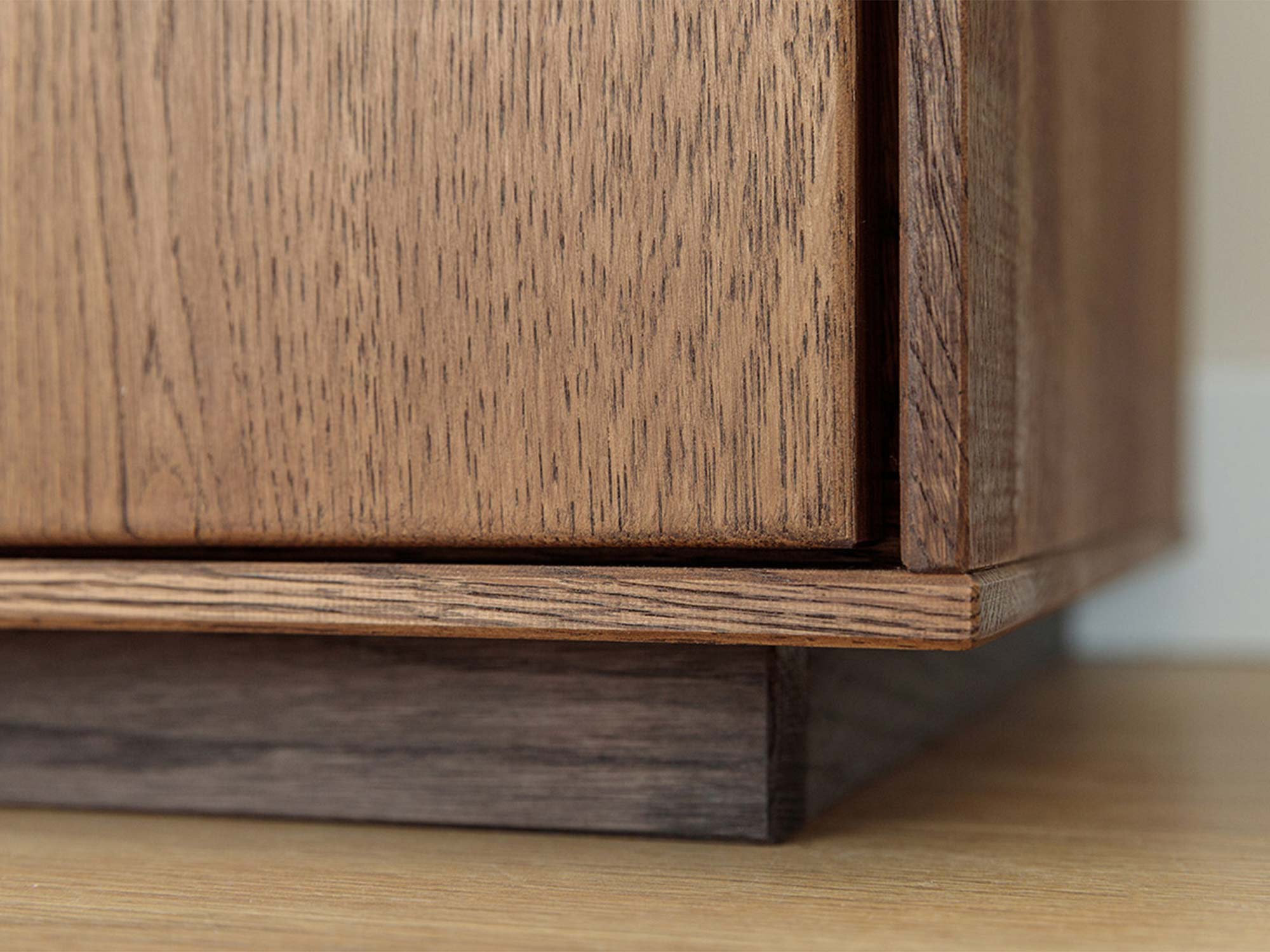 Detal dolnej części komody tabacco z cokołem i usłojeniem drewna