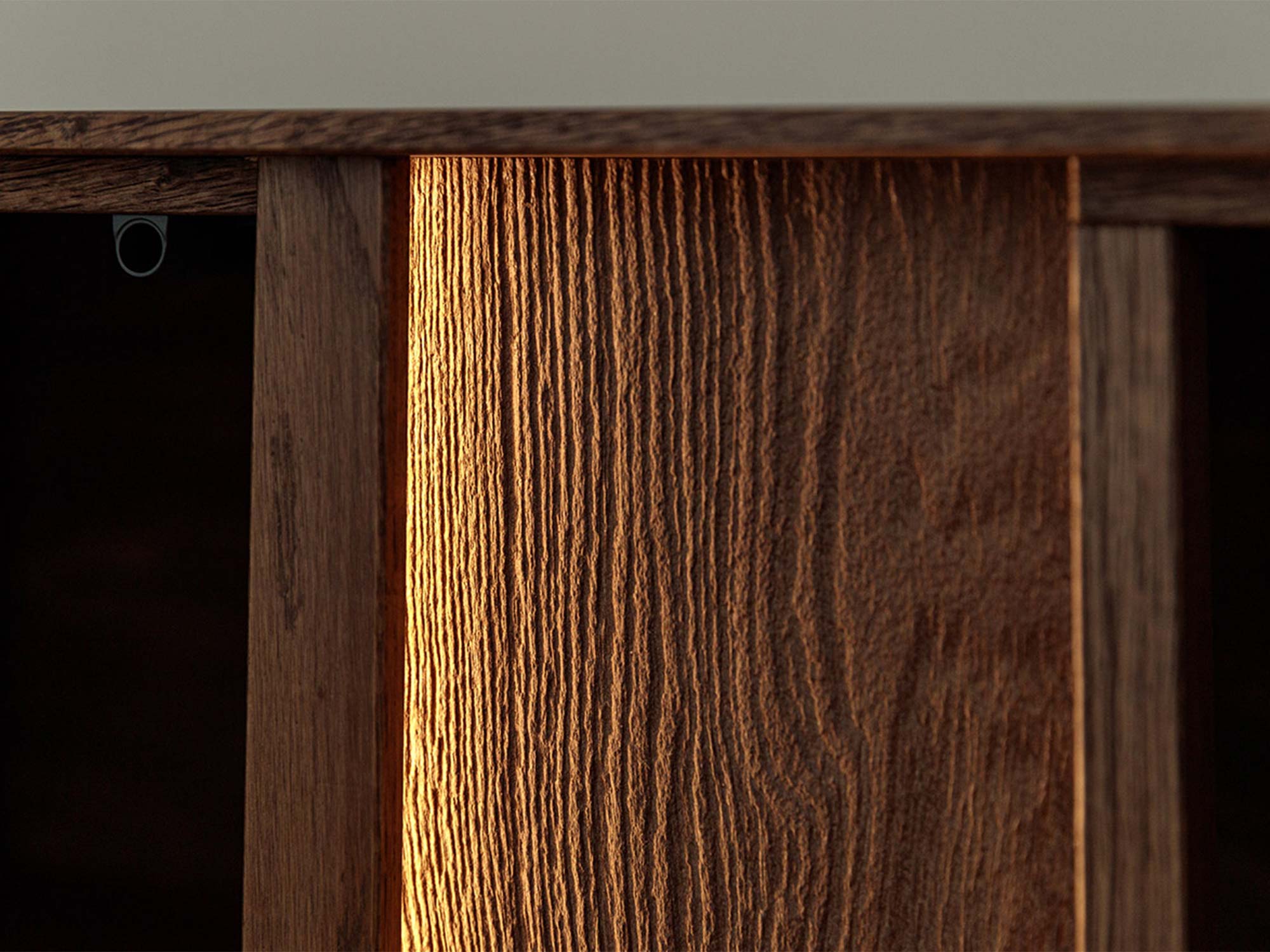 Detal drzwi komody tabacco z podświetleniem LED i usłojeniem drewna