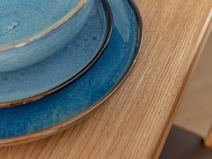 Miniaturka 4 - Detal narożnika blatu stołu dębowego z talerzami ceramicznymi