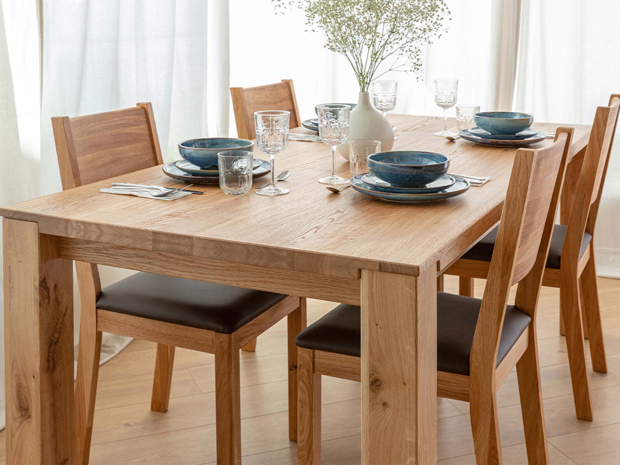 Stół dębowy w aranżacji jadalni z krzesłami i zastawą stołową