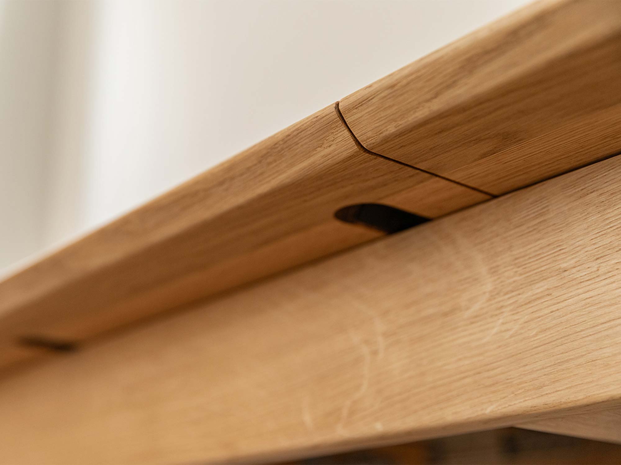 Detal krawędzi blatu stołu dębowego z widocznym mechanizmem