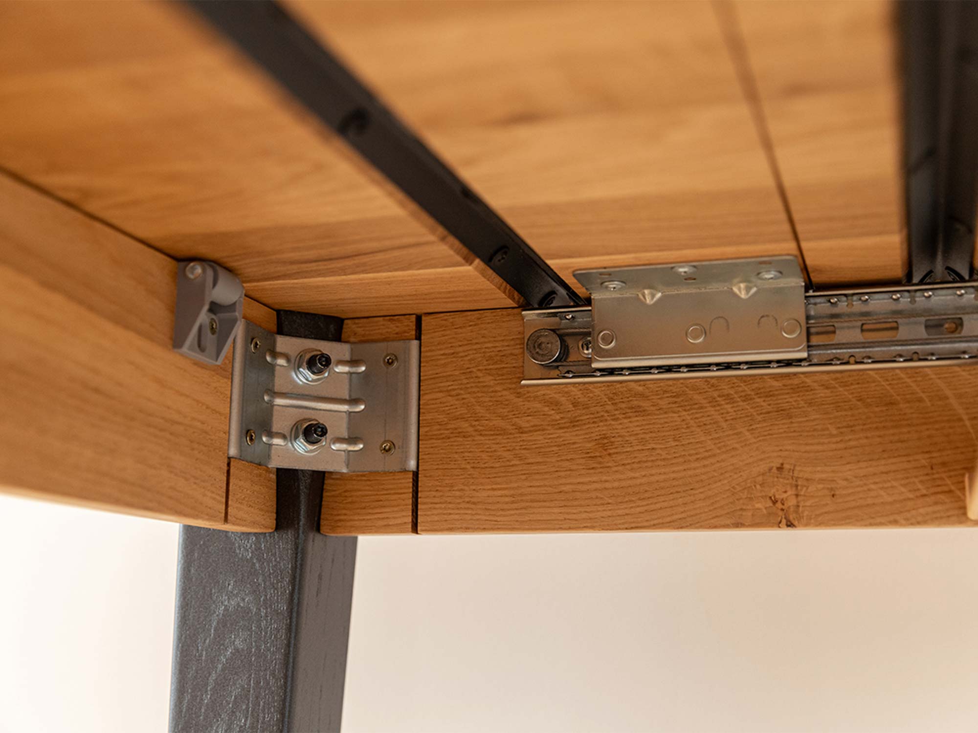 Spód blatu stołu dębowego z ciemnymi nogami konstrukcja i prowadnice
