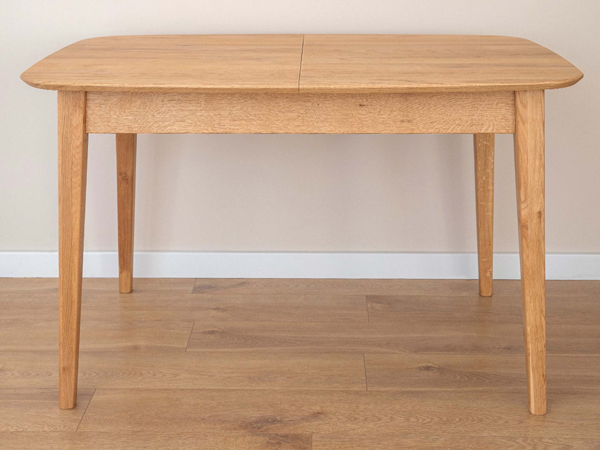 Stół dębowy prostokątny jasny rozkładany na drewnianej podłodze