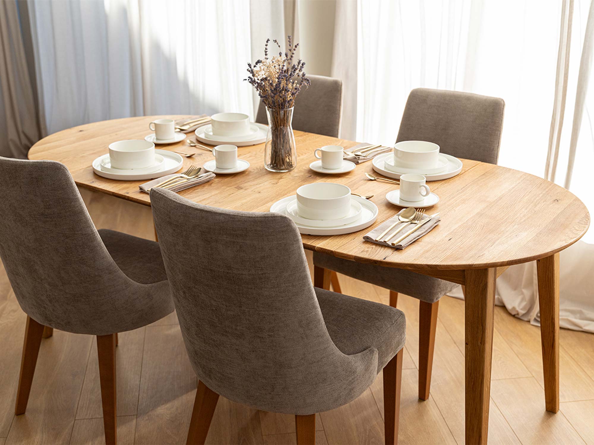 Stół dębowy rozkładany owalny w aranżacji jadalni z szarymi krzesłami