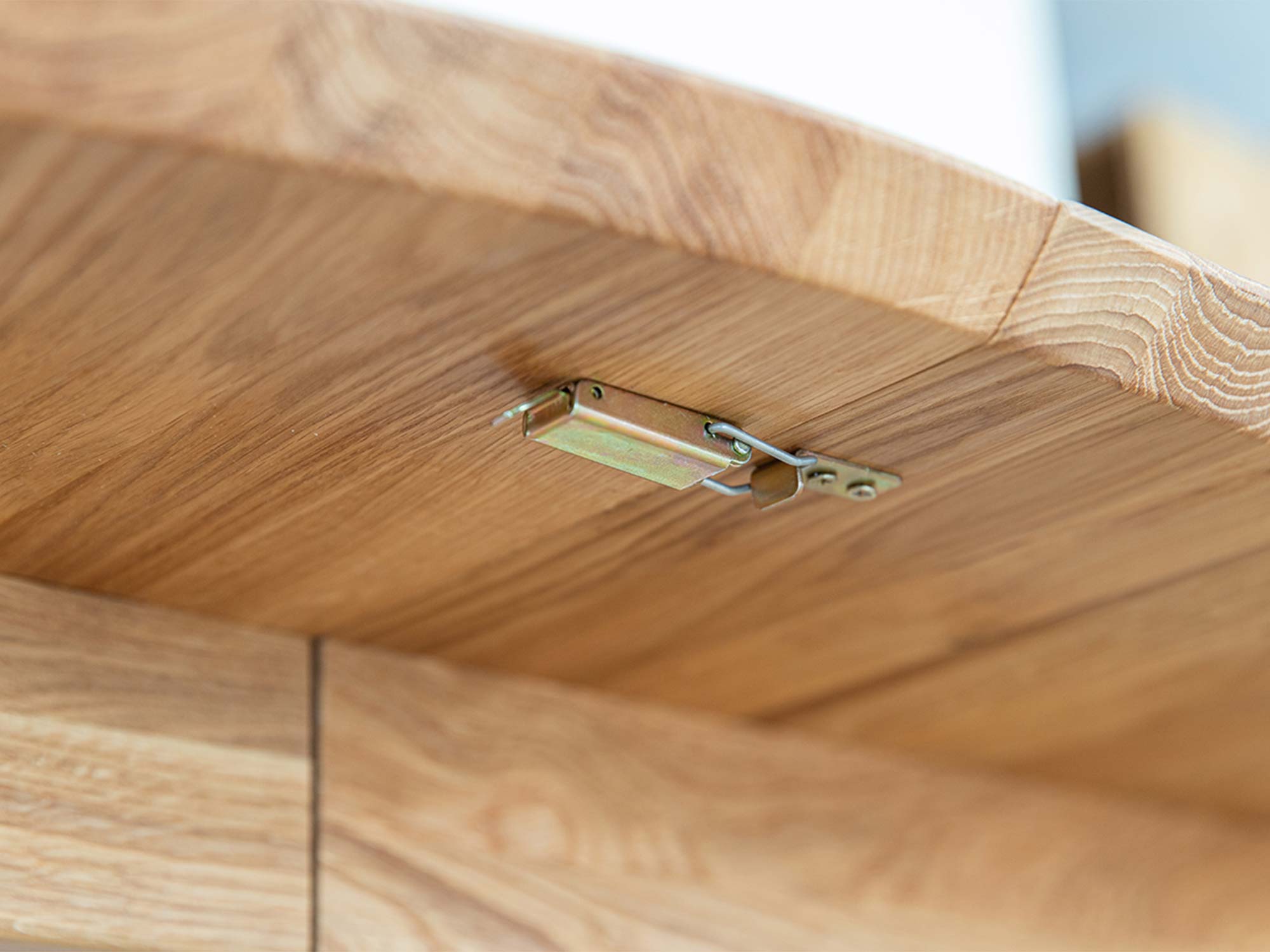 Spód blatu stołu dębowego rozkładanego z widocznym mechanizmem zatrzasku