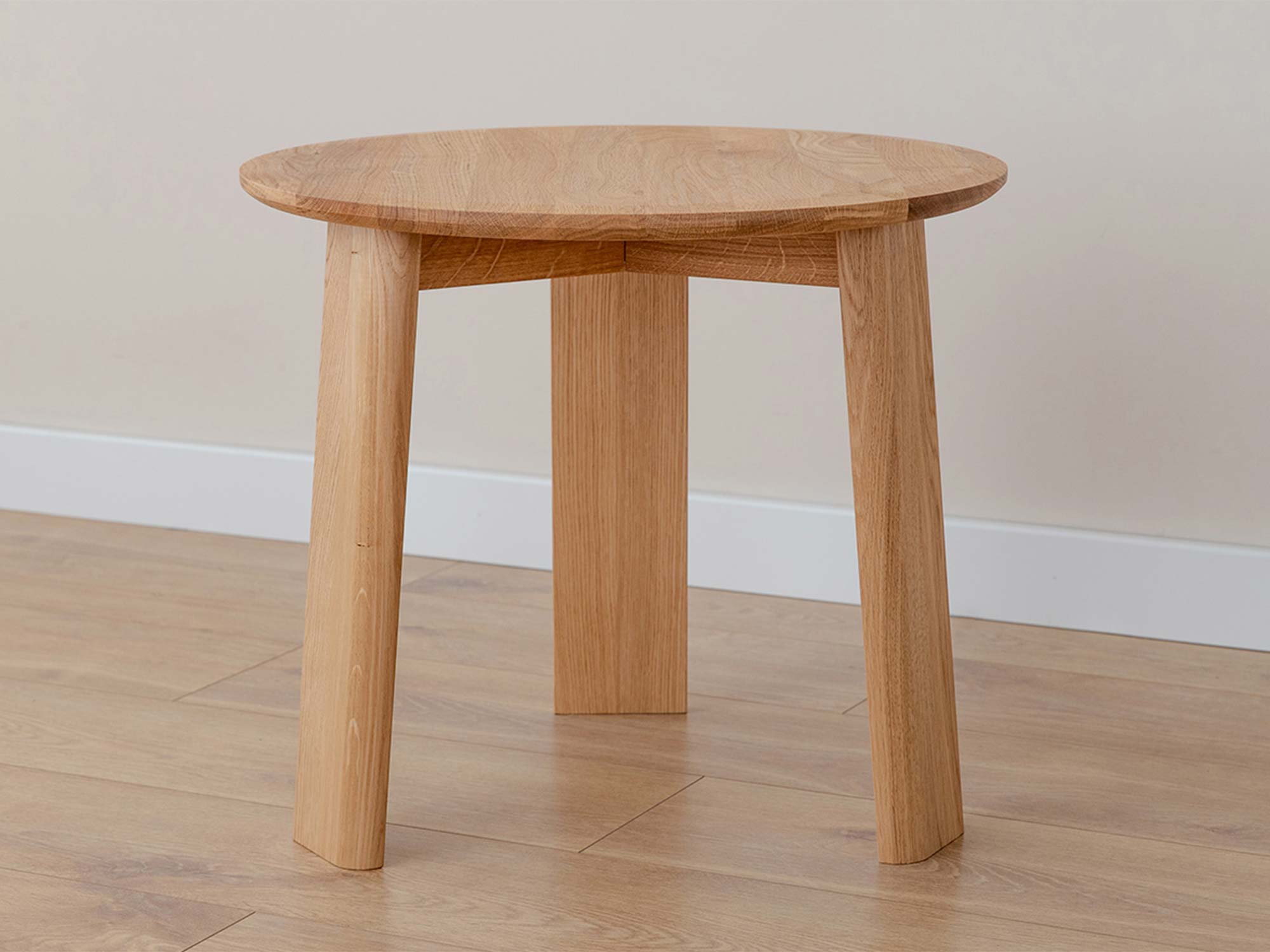 Stolik kawowy okrągły dębowy z trzema nogami w aranżacji wnętrza