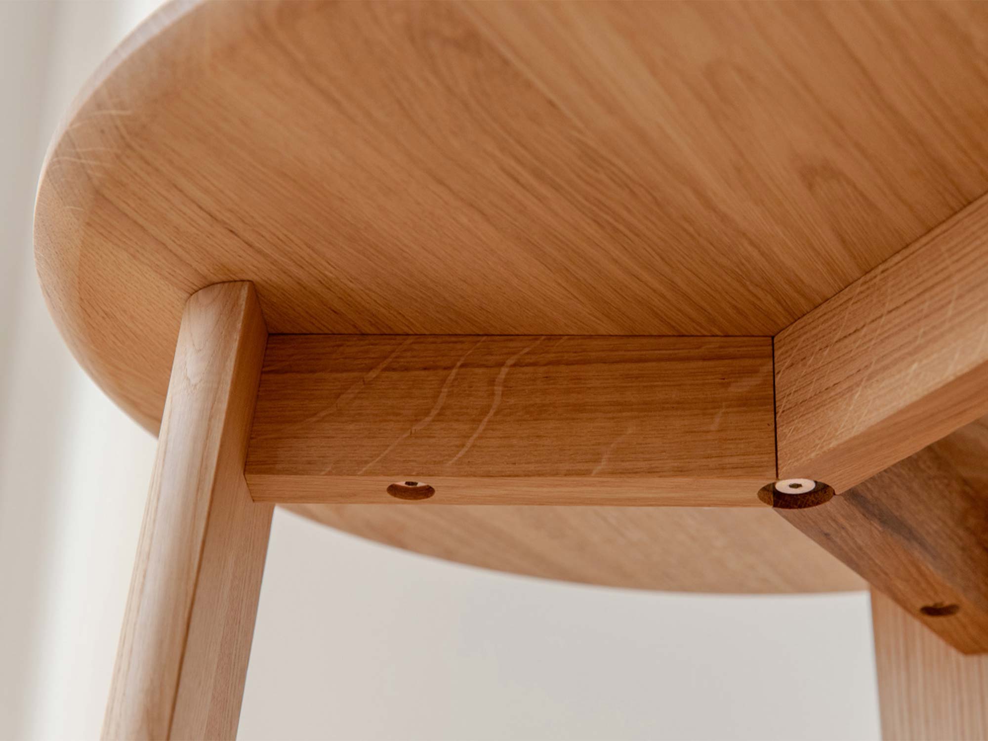 Detal spodu blatu stolika kawowego dębowego z widoczną ramą i śrubami