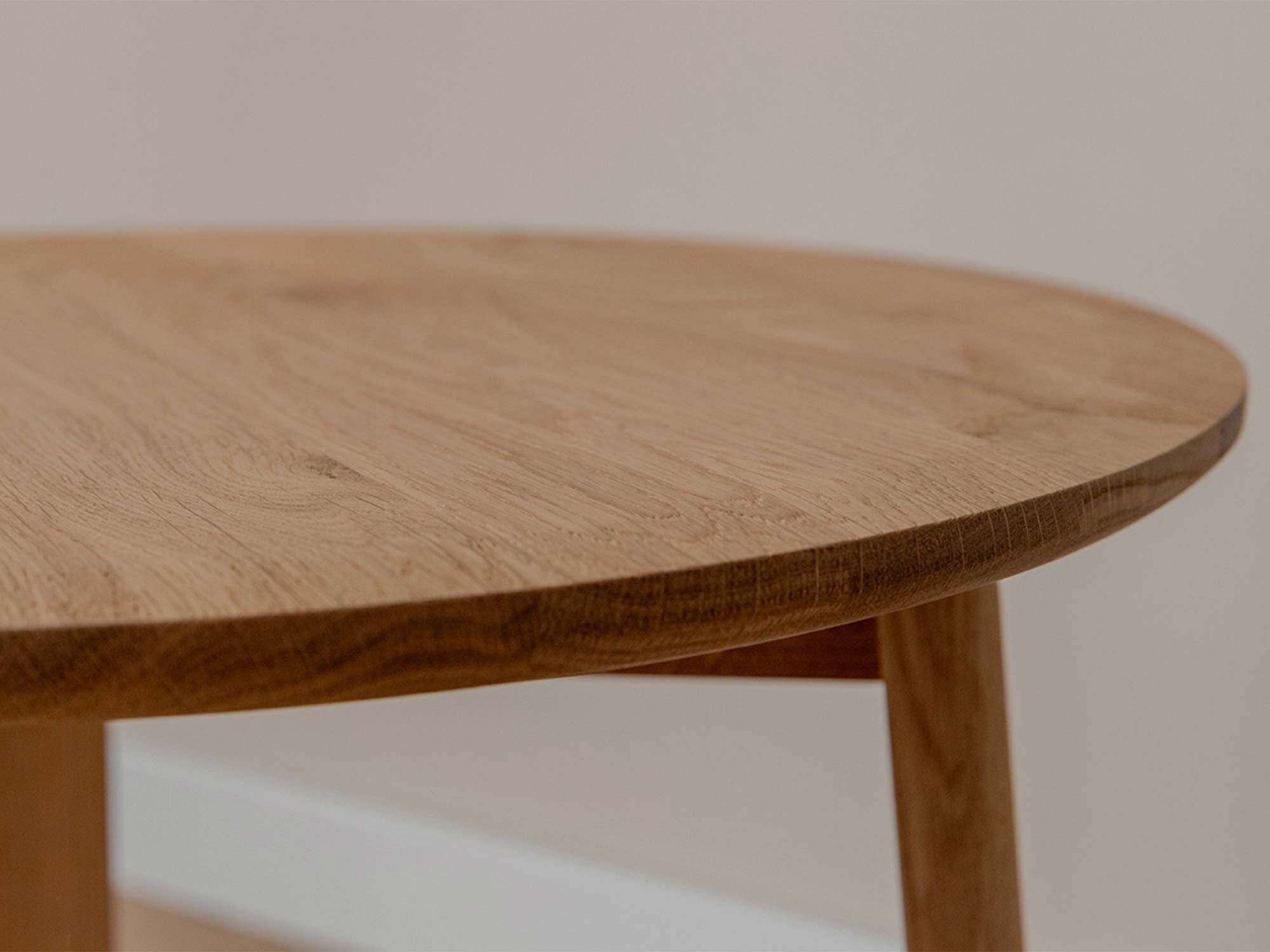 Detal usłojenia okrągłego blatu dębowego stolika kawowego z zaokrągloną krawędzią