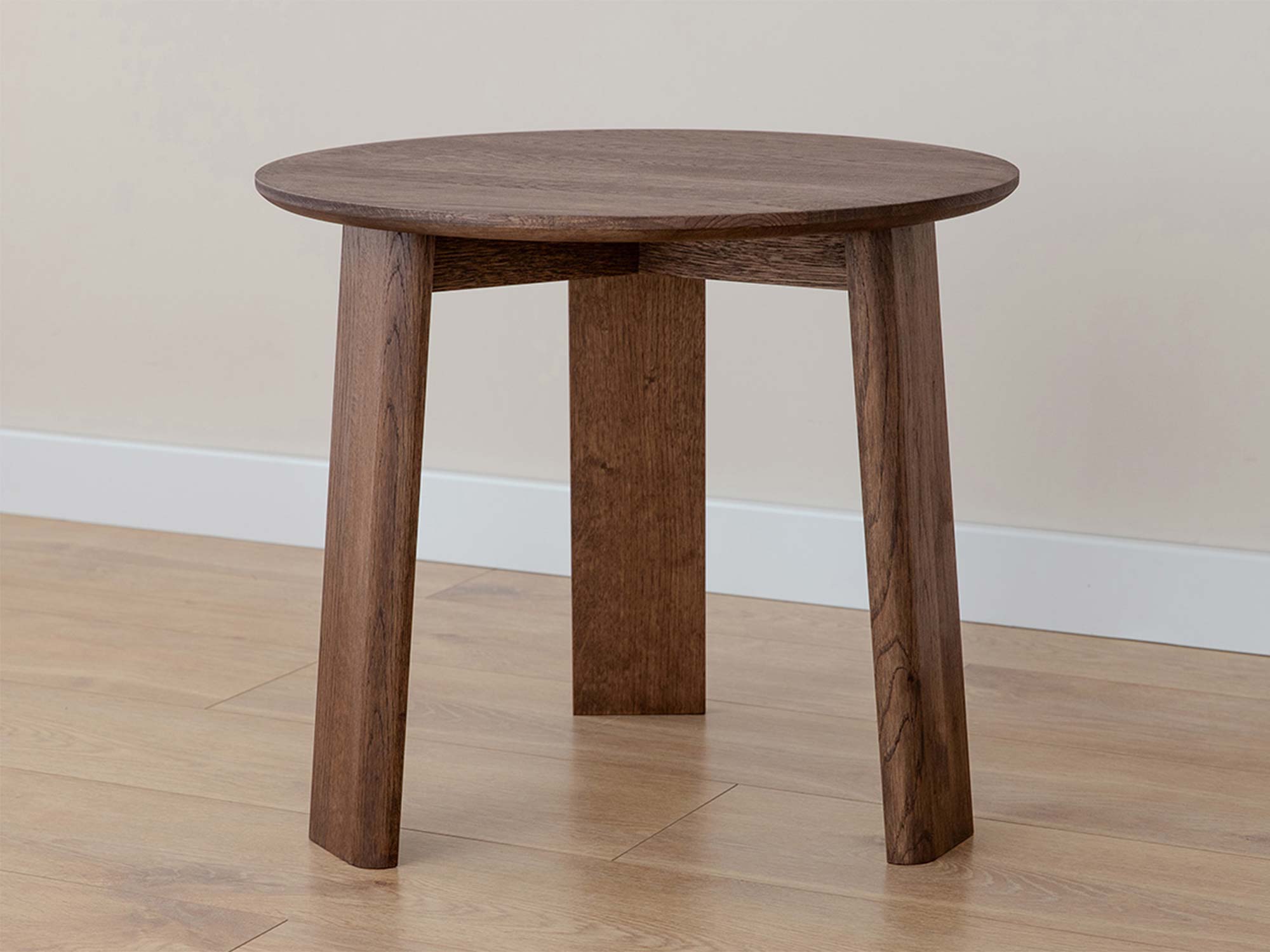 Stolik kawowy okrągły dębowy tabacco z trzema nogami w aranżacji wnętrza