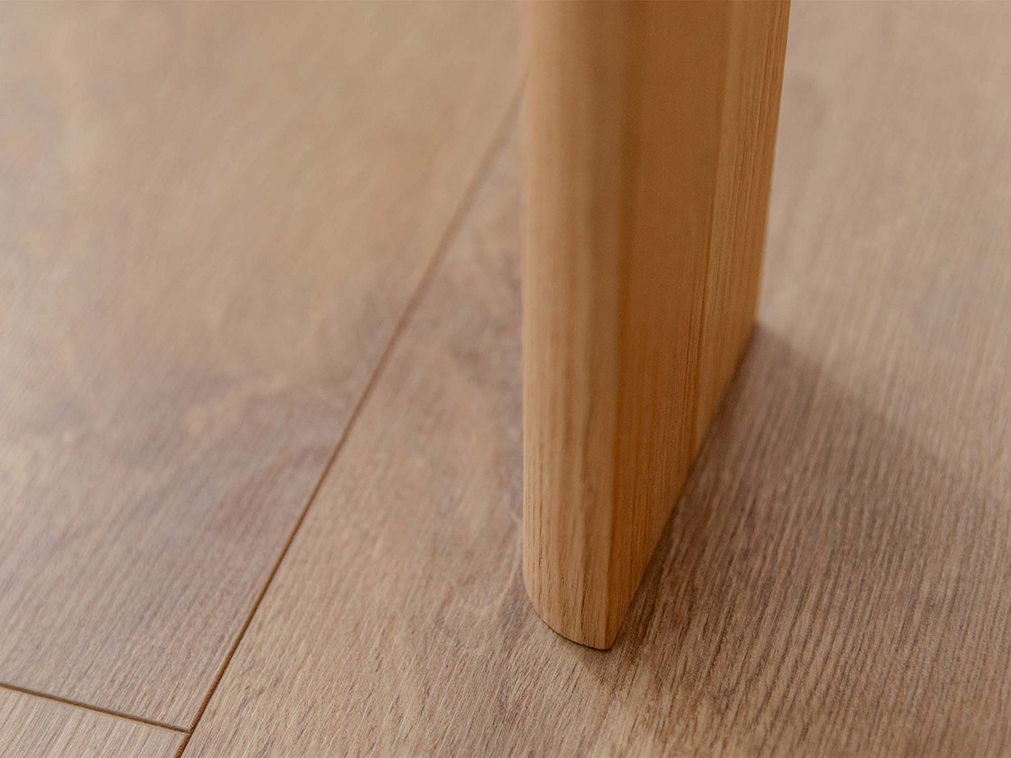 Detal nogi stolika kawowego dębowego na drewnianej podłodze zbliżenie