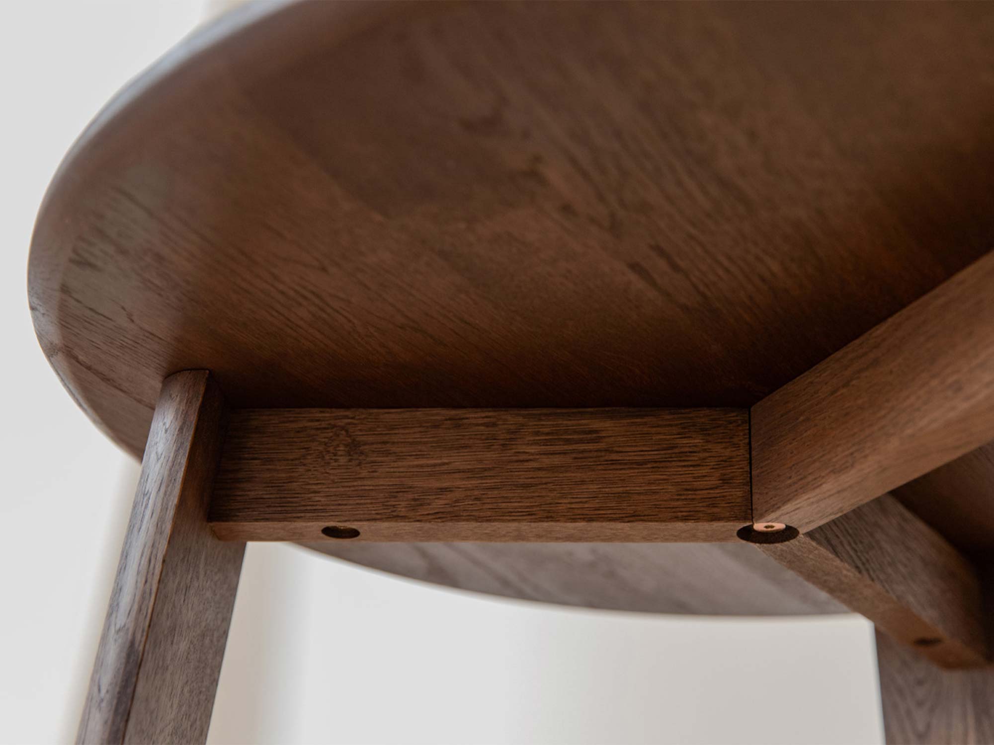 Detal spodu blatu stolika kawowego dębowego tabacco z widoczną ramą i nogą