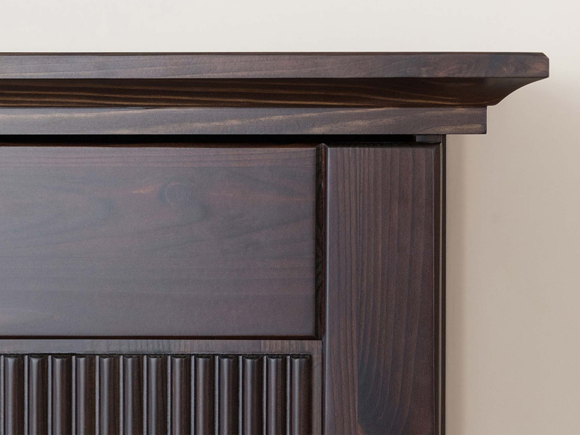 Detal ryflowanego panelu drzwi szafy drewnianej ciemnobrązowej zbliżenie