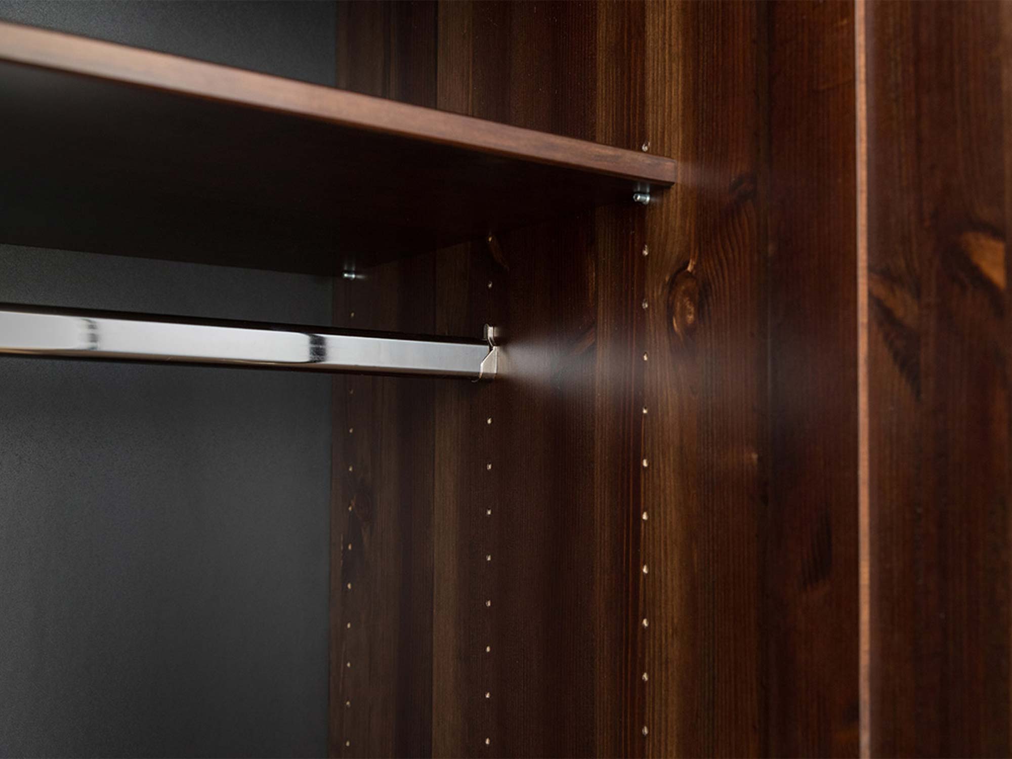 Detal bocznej ściany szafy drewnianej ciemnobrązowej z usłojeniem