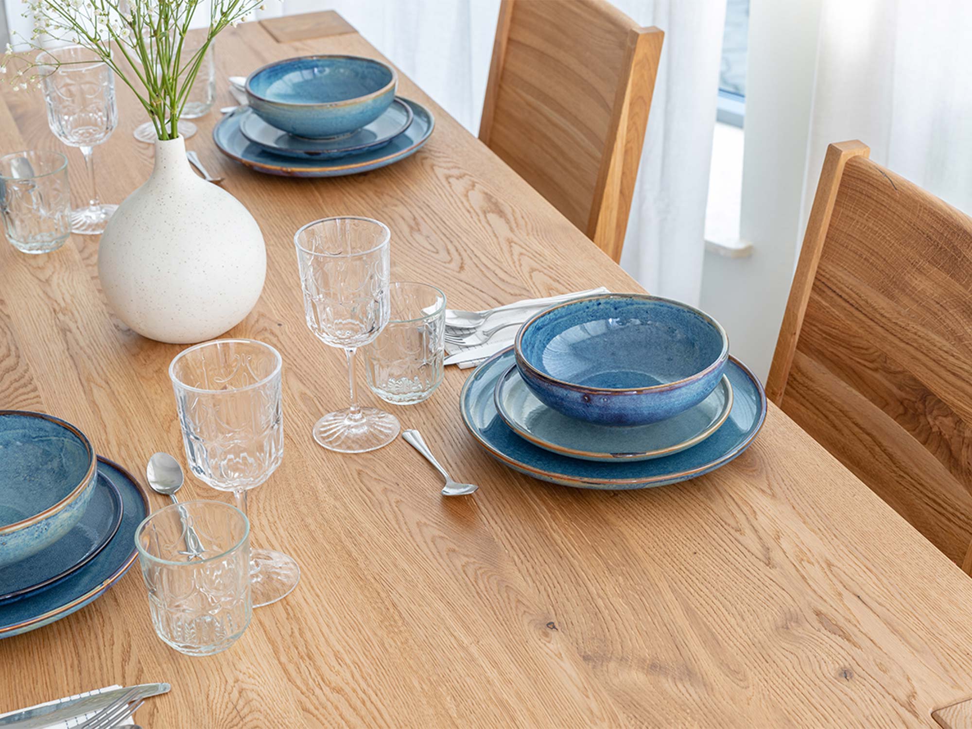 Blat stołu drewnianego dębowego jasnego z zastawą i wazonem detal zbliżenie