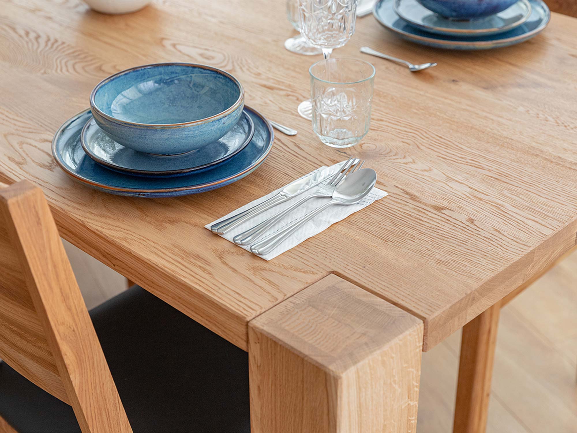 Narożnik blatu i noga stołu drewnianego dębowego jasnego z zastawą detal