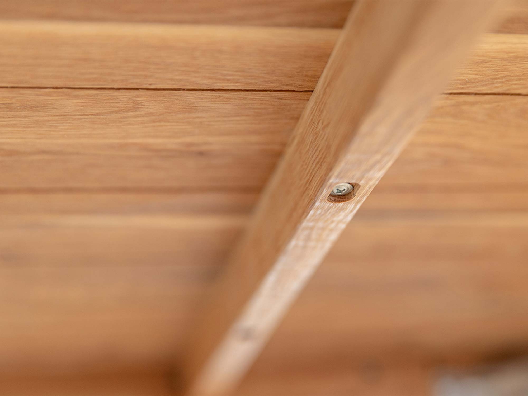 Spód blatu stołu drewnianego dębowego jasnego z wkrętem montażowym detal