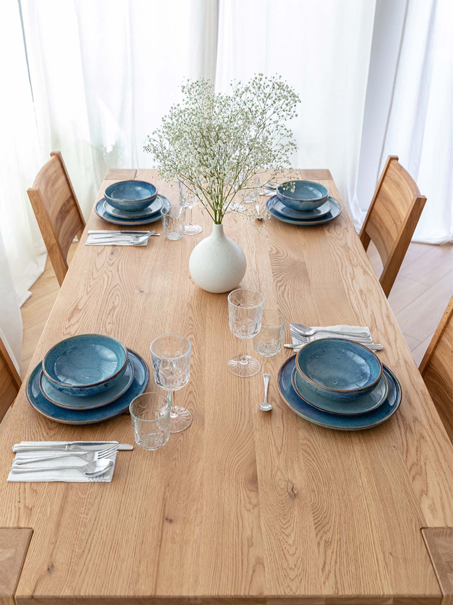 Blat stołu drewnianego dębowego jasnego z zastawą i wazonem widok z góry