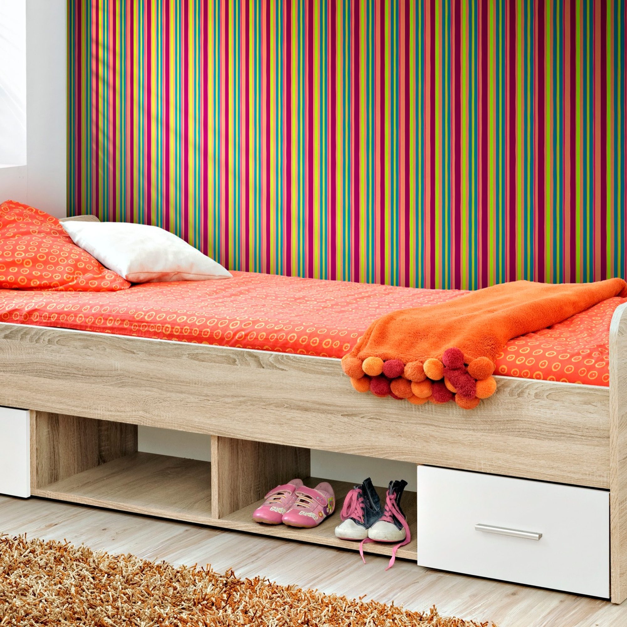 Dinvoro Bett mit Schubladen vor einer bunten Tapete