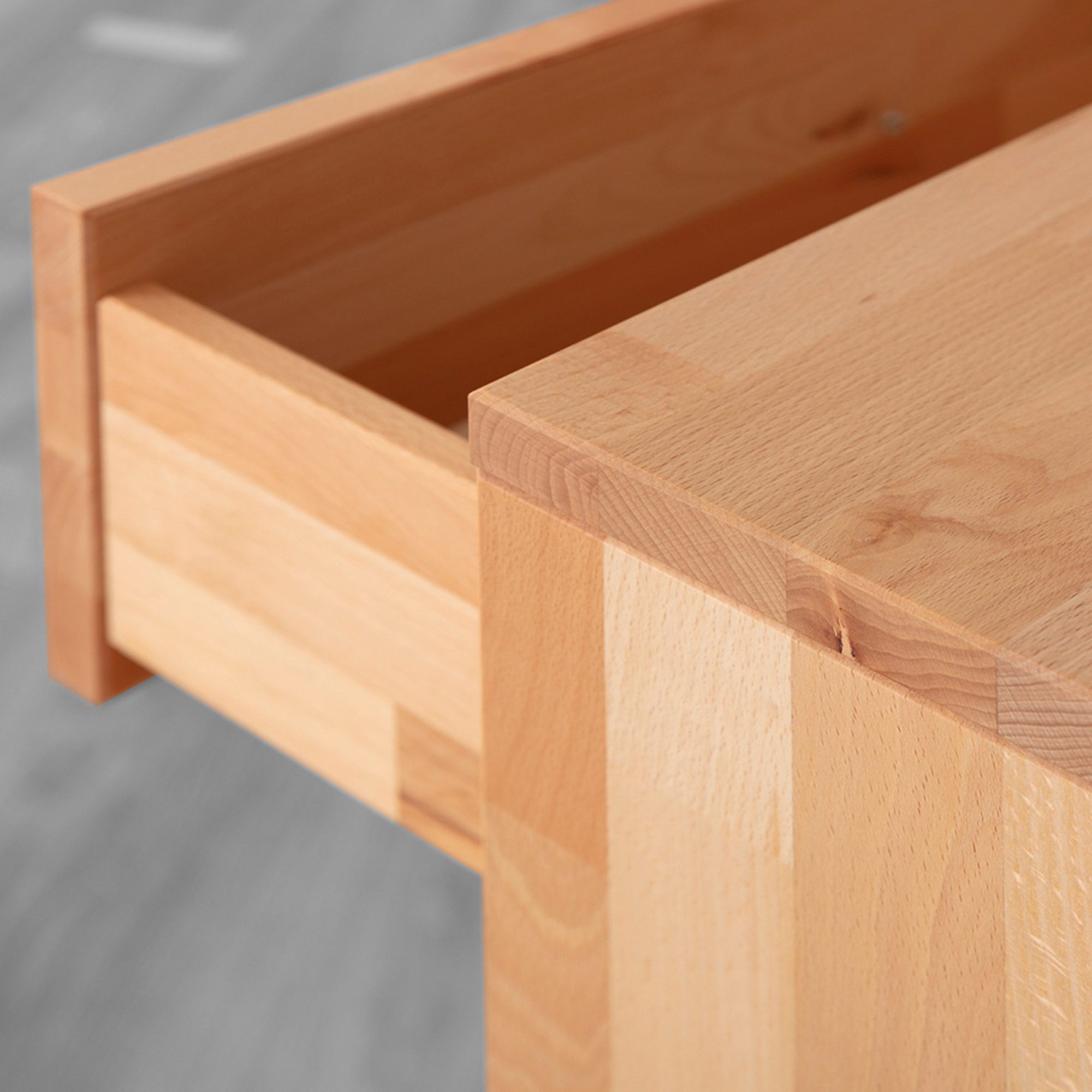 Kommode Belisa aus Buche – Detail einer geöffneten Schublade und Holzkante der Deckplatte